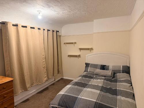 a bedroom with a bed with a plaid blanket at Warn Cossy Luxe Room in Addington