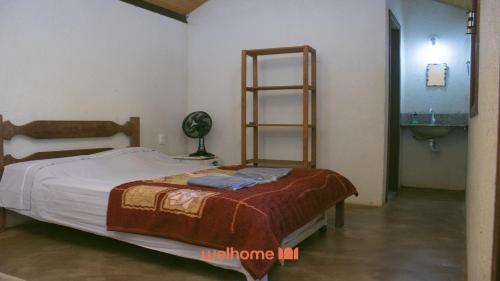 um quarto com uma cama e um banheiro com uma pia em Chale Rural em Nova Lima com Vista para o Jardim em Macacos