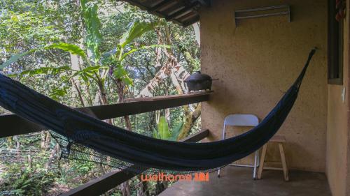 uma rede pendurada do lado de uma casa em Chale Rural em Nova Lima com Vista para o Jardim em Macacos