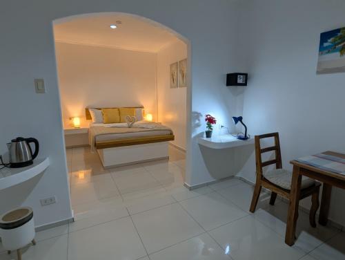 a bedroom with a bed and a table and a chair at Astillo's Guest Houses in Moalboal