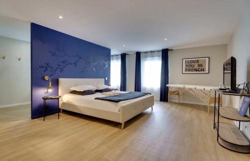 a bedroom with a bed and a blue wall at Maison avec espace bien-être privé in Mareuil-sur-Lay