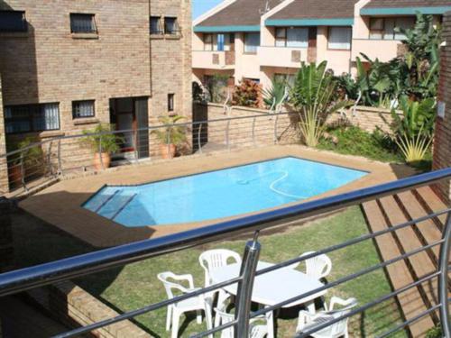 a balcony with a swimming pool with chairs and a table at Villa Siesta Flat No 1 in Margate