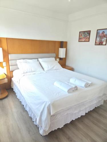 a bedroom with a large white bed with two towels on it at Studio Corcovado in Rio de Janeiro