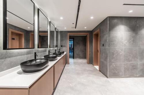 a bathroom with a row of sinks and mirrors at Samaya Holiday Homes - Cloud Stylish Suites with Balcony in Dubai