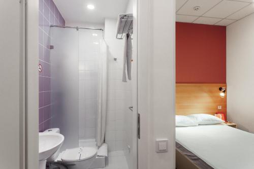 オデッサにあるOrange Hotelのバスルーム(シャワー、トイレ付)、ベッド1台が備わります。