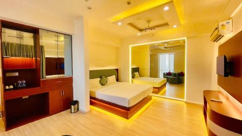 a bedroom with two beds and a television in it at Hotel Four Season - Gomtinagar - Lucknow in Lucknow