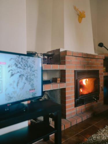 a tv sitting in front of a brick fireplace at Casa das Essências, Quinta de Santo António in Covilhã
