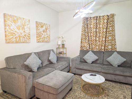 a living room with two couches and a table at Contemporary Urban Home in Niagara Falls