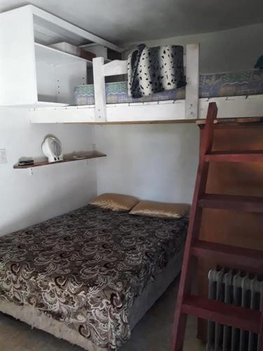 a bed in a room with shelves and a ladder at Sueño magico in Chapadmalal