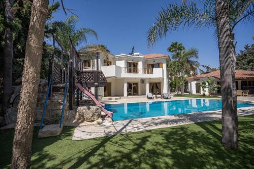 Blue Pearl Villa - 6 Bedroom في بيلا: فيلا بمسبح والنخيل