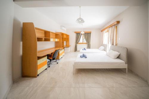 Blue Pearl Villa - 6 Bedroom في بيلا: غرفة نوم بسريرين ومكتب فيها