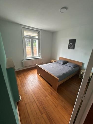 una camera da letto con un letto e un pavimento in legno di Comme a la maison a Thun-Saint-Martin