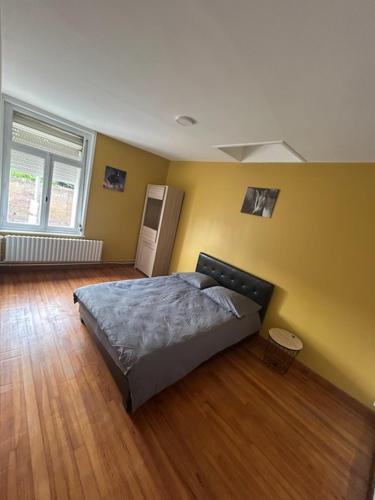 una camera da letto con un letto e un pavimento in legno di Comme a la maison a Thun-Saint-Martin