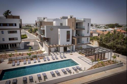 an aerial view of a building with a swimming pool at Kalamon Luxury Suite 105 w Pool & Gym in Livadhia