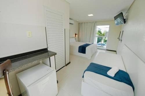 uma sala com um quarto com uma cama e uma televisão em Pousada Oásis Tropical em Porto de Galinhas