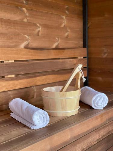 a bucket and two rolled towels on a shelf at Vöröskő- Házmester- Balatonalmádi in Balatonalmádi