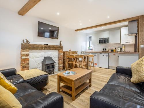 a living room with a couch and a fireplace at The Hayloft-Uk34015 in Godshill
