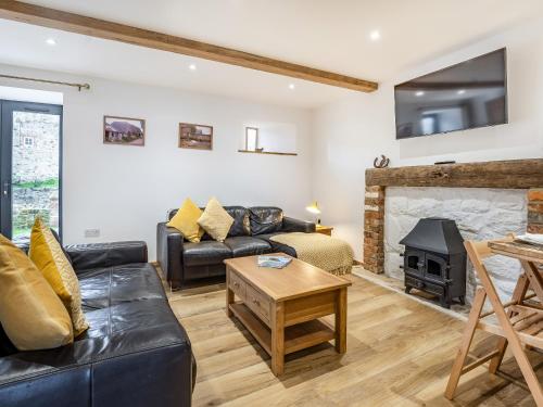 a living room with a couch and a fireplace at The Hayloft-Uk34015 in Godshill