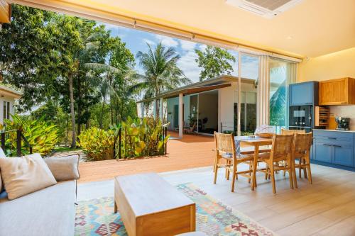 een open woonkamer met een tafel en stoelen bij Luxury Villa - Pool - Gym - Steam Room - Garden in Ko Pha Ngan