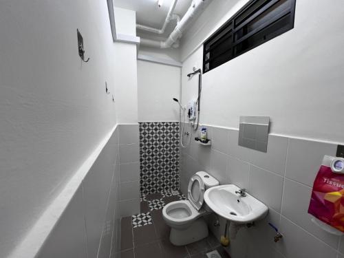 a small bathroom with a toilet and a sink at Homestay Kesidang in Seri Iskandar