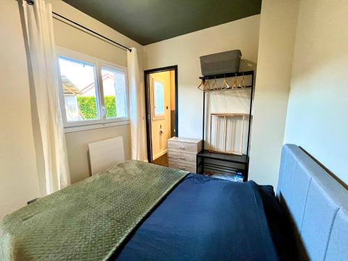 Gîte avec Terrasse et parking privé في Charnècles: غرفة نوم بسرير ازرق ونافذة