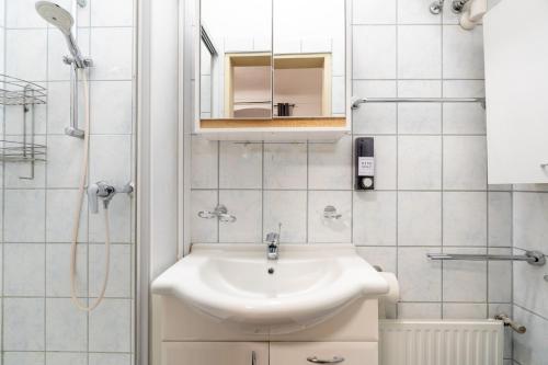 a white bathroom with a sink and a mirror at Quiet Studio - 2 Single Beds - Central - Netflix in Leoben