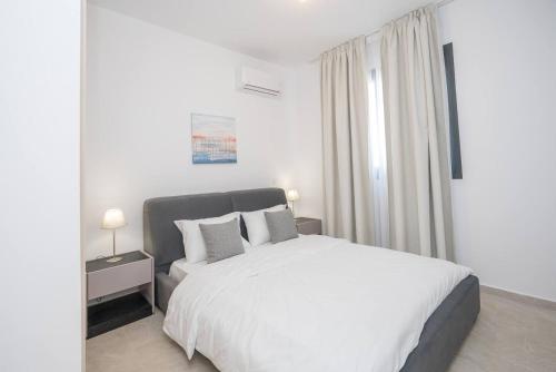 拉纳卡Kalamon Luxury Suite 202 w Pool and Gym的一间带床和窗户的白色卧室