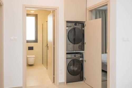 拉纳卡Kalamon Luxury Suite 202 w Pool and Gym的一间带洗衣机和烘干机的浴室