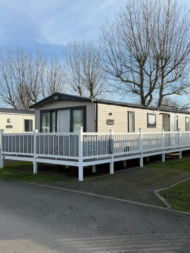 een stacaravan met een wit hek eromheen bij Bishops Beach Stays in Walton-on-the-Naze