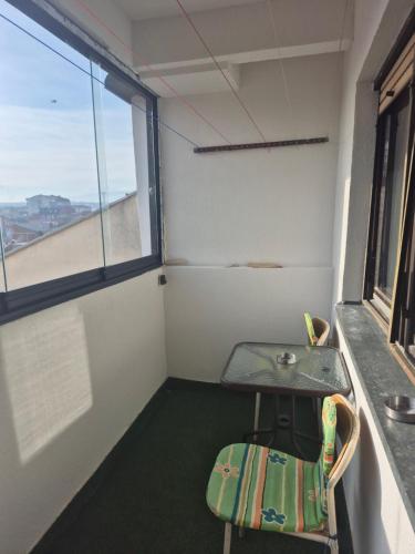 a small table and chair in a room with a window at M comfort in Kumanovo
