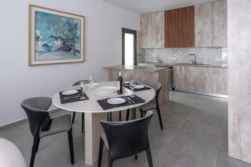 LivadhiaKalamon Luxury Suite 203 w Pool and Gym的厨房里设有1间带桌椅的用餐室