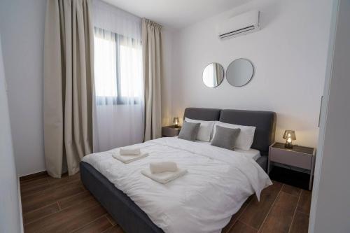LivadhiaKalamon Luxury Suite 203 w Pool and Gym的卧室里有一张白色的大床，床上有两条毛巾
