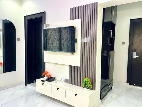 a room with a white cabinet and a mirror at Fadaka Manor in Ibadan