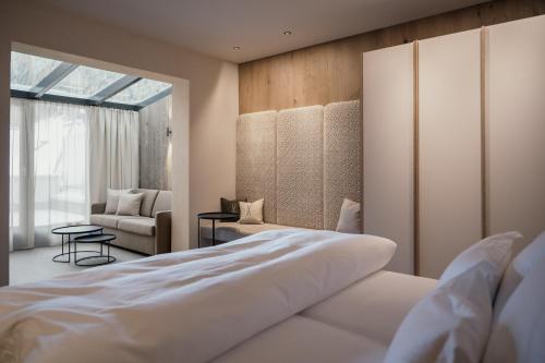 a bedroom with a large white bed and a chair at Alpvita Piz Tasna in Ischgl