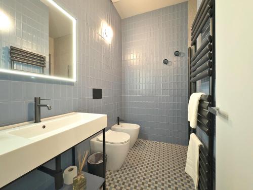 un bagno con lavandino, WC e specchio di Cinisca Suite Blue a Bologna