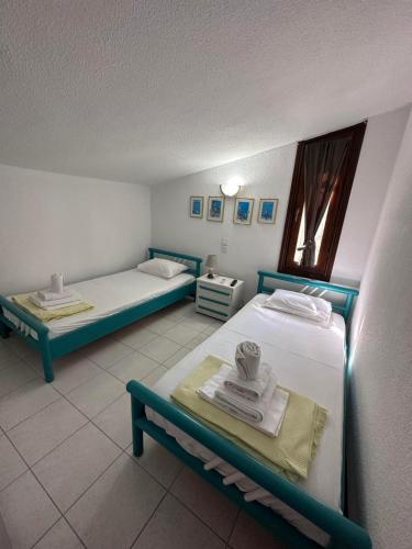 a room with two beds and a table with towels at Sani Villa Maria in Sani Beach