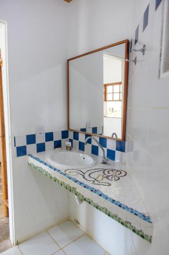 a bathroom with a sink and a mirror at Flat Flor da Terra in Itacaré