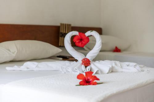 a bed with swan towels and flowers on it at Flat Flor da Terra in Itacaré