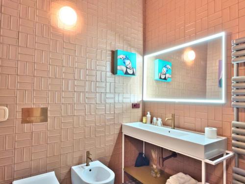 un bagno con lavandino, specchio e WC di Cinisca Suite Rose a Bologna