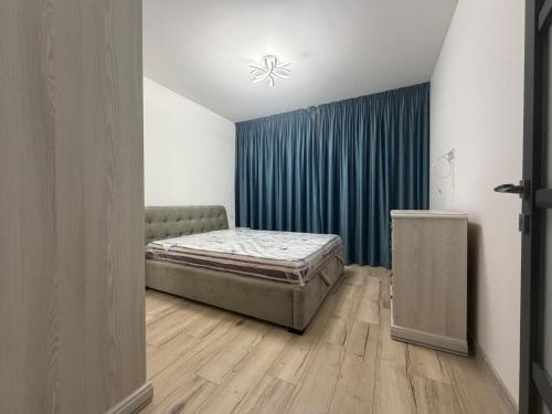 een slaapkamer met een bed en een blauw gordijn bij Altheda Living Stejari 4B in Suceava