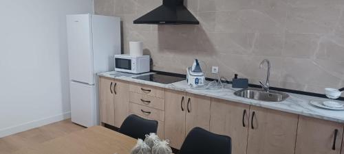 una cucina con un lavello e un frigorifero bianco di Pensión San Cristóbal by Bossh! Hotels a Cuenca