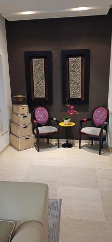 a living room with two chairs and a table at Maison 3 in Sidi Daoud