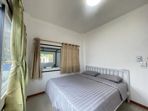 a bedroom with a bed and a window at Haiya Holiday House 2 in Ban Hua Phrong