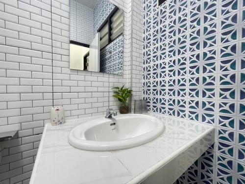 a white bathroom with a sink and a mirror at Haiya Holiday House 2 in Ban Hua Phrong