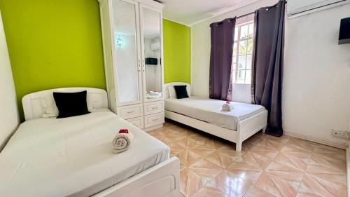 Giường trong phòng chung tại Villa Cocotier Piscine privée et plage à 5 mn à pied