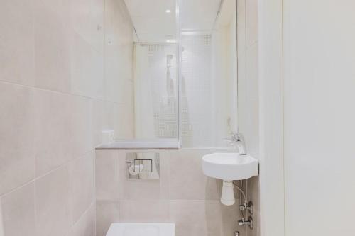 een witte badkamer met een wastafel en een toilet bij Copenhagen Getaway Cute Studio for Two 7 in Kopenhagen