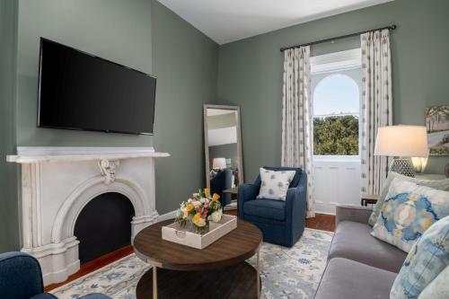 a living room with a fireplace and a tv at Hamilton Turner Inn in Savannah