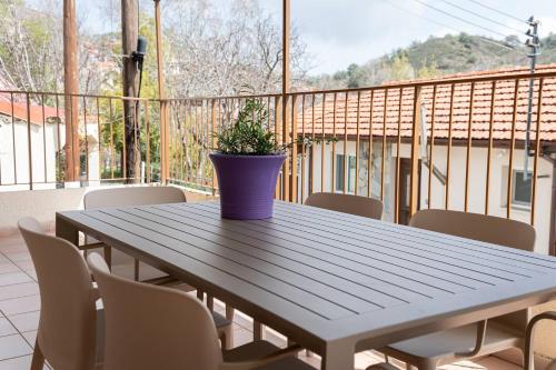 a blue vase sitting on a wooden table on a balcony at Hubstay Hillside Residence with Private Jacuzzi in Platres