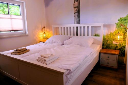 ein weißes Bett mit Handtüchern darauf in einem Schlafzimmer in der Unterkunft Ferienwohnung Brama in Reinhardshagen
