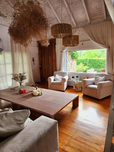 a living room with couches and a wooden table at Casa del Cielo in La Cumbre